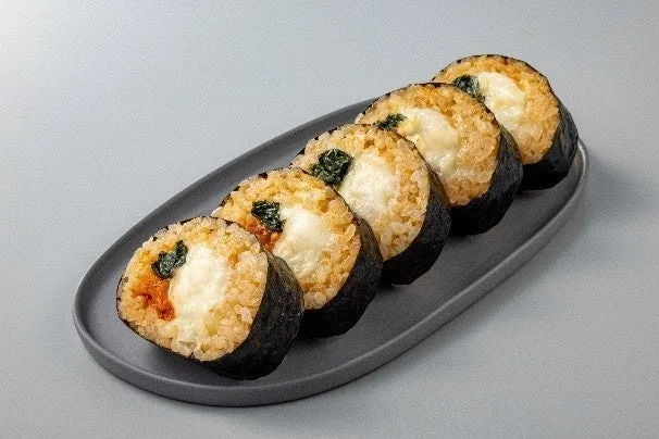 お皿に並んだおにぎりの写真です。おにぎりは、ご飯、海苔、チーズ、その他具材で構成されています。